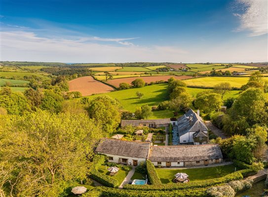 Ariel view of the farm, cottages and gardens with the sea beyond